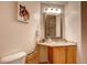 Charming bathroom with a granite-topped vanity, decorative mirror, and a toilet at 20341 E 48Th Pl, Denver, CO 80249