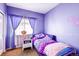 Bright bedroom with purple walls, a window with sheer curtains and a unique butterfly-themed bedspread at 20341 E 48Th Pl, Denver, CO 80249