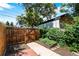 Backyard features a wooden gate, planting beds, and patio at 3319 Newton St, Denver, CO 80211