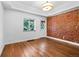 Bright bedroom featuring hardwood floors, exposed brick wall and natural lighting at 3319 Newton St, Denver, CO 80211