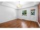 Bright bedroom with wood floors, ample sunlight, and an exposed brick accent wall at 3319 Newton St, Denver, CO 80211