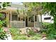 Charming front exterior featuring a cozy porch, mature trees, and professionally landscaped yard at 3319 Newton St, Denver, CO 80211