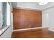 Bright living room featuring a brick wall and hardwood floors at 3319 Newton St, Denver, CO 80211