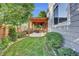 Landscaped backyard with stone-lined garden beds and a dining patio under a pergola at 8489 S Quay St, Littleton, CO 80128