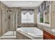 Bathroom with a combined glass-door shower and soaking tub under a large window at 8489 S Quay St, Littleton, CO 80128