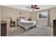This bedroom boasts carpet floors, neutral walls, ceiling fan, and a bright window at 8489 S Quay St, Littleton, CO 80128