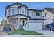 Beautiful two-story home with a covered porch, stone accents, well-maintained lawn, and landscaping at 8489 S Quay St, Littleton, CO 80128