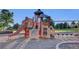 Community playground featuring climbing structures, slides, and swings on a wood chip surface at 8489 S Quay St, Littleton, CO 80128