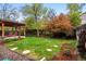 Landscaped backyard features a patio, a well-maintained lawn, and mature trees and bushes at 13313 Cherry Cir, Thornton, CO 80241
