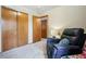 Carpeted bedroom featuring a recliner, closet, and view into another room at 13313 Cherry Cir, Thornton, CO 80241