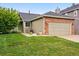 Charming exterior with a brick-accented two-car garage and a well-manicured lawn at 13313 Cherry Cir, Thornton, CO 80241
