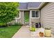 Charming front porch with a green door, colorful planters, and a cozy seating area at 13313 Cherry Cir, Thornton, CO 80241