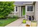 Inviting front entrance with a vibrant green door, tidy landscaping, and decorative planters at 13313 Cherry Cir, Thornton, CO 80241