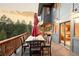 A wooden deck has an outdoor dining set under an umbrella, perfect for enjoying meals and entertaining at 7290 Timber Trail Rd, Evergreen, CO 80439