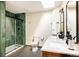 Bathroom with dual sink marble vanity, mosaic-tiled flooring, skylight and a glass-enclosed shower at 7290 Timber Trail Rd, Evergreen, CO 80439