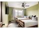 Bright bedroom with dual twin beds, ceiling fan, and hillside views at 7290 Timber Trail Rd, Evergreen, CO 80439