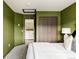 Cozy bedroom with olive green accent wall and large closet space at 7290 Timber Trail Rd, Evergreen, CO 80439