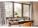 Desk Area: Wood desktop with shelves frames three windows with views to the outdoors and patterned drapes at 7290 Timber Trail Rd, Evergreen, CO 80439