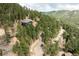 A beautiful home is nestled among lush green trees on a hillside, offering privacy and scenic beauty at 7290 Timber Trail Rd, Evergreen, CO 80439