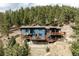 Charming mountain home featuring a large deck, wood accents, and a picturesque setting among the trees at 7290 Timber Trail Rd, Evergreen, CO 80439