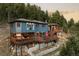 Stunning exterior view of home with large deck and forest views at 7290 Timber Trail Rd, Evergreen, CO 80439