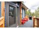 The front porch features a screen door, red chairs, and a grill, creating a relaxing outdoor space at 7290 Timber Trail Rd, Evergreen, CO 80439