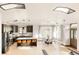 Open concept kitchen with island and dining area offers natural light and stylish finishes at 7290 Timber Trail Rd, Evergreen, CO 80439