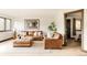 Comfortable living room features leather seating and an adjacent bedroom through a dark-trimmed doorway at 7290 Timber Trail Rd, Evergreen, CO 80439