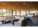 This covered patio offers a comfortable seating area and a hot tub, great for relaxation and entertainment at 7290 Timber Trail Rd, Evergreen, CO 80439