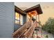 A stairway leads to a porch area with overhead lighting, adding charm and functionality to the entrance at 7290 Timber Trail Rd, Evergreen, CO 80439