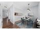 Bright dining room featuring modern light fixture, wood floors, blue accent rug and seating for six at 6011 Yarrow St # I, Arvada, CO 80004