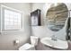 Cozy half bathroom with a modern round mirror and cabinet for storage at 10071 E 142Nd Ave, Brighton, CO 80602