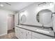 Modern bathroom with dual sinks, white cabinets, gray countertops, decorative mirrors, and tiled flooring at 10071 E 142Nd Ave, Brighton, CO 80602