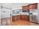 Open-concept kitchen features dark wood cabinets, granite counters, stainless steel appliances, and a breakfast bar at 10071 E 142Nd Ave, Brighton, CO 80602