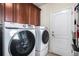 Convenient laundry room with modern front load washer and dryer and storage cabinets at 10071 E 142Nd Ave, Brighton, CO 80602