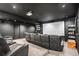 A home theater room features black walls, a large screen, and tiered seating for a cinematic viewing experience at 10071 E 142Nd Ave, Brighton, CO 80602