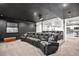 A home theater room features black walls, a projector screen, and tiered seating for a cinematic viewing experience at 10071 E 142Nd Ave, Brighton, CO 80602