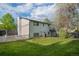 Backyard featuring a well-maintained lawn, white picket fence, mature trees, and the home's exterior at 794 W Elati Cir, Littleton, CO 80120