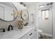 Bright bathroom featuring double sinks with black fixtures, large vanity mirror and sleek white cabinets at 794 W Elati Cir, Littleton, CO 80120