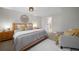 Bright bedroom with wooden bedframe, neutral walls and a view into the walk-in closet and soft gray armchair at 794 W Elati Cir, Littleton, CO 80120