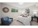 Cozy bedroom featuring a chair with a throw blanket, decorative black and white floral painting, and neutral walls at 794 W Elati Cir, Littleton, CO 80120