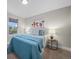 Cozy bedroom with bright window, soft teal comforter, a fluffy white pillow and a side table at 794 W Elati Cir, Littleton, CO 80120