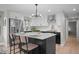 Modern kitchen with white cabinets, stainless steel appliances, and a black island with seating at 794 W Elati Cir, Littleton, CO 80120