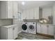 Clean laundry room with white cabinets, new washer and dryer and modern flooring at 794 W Elati Cir, Littleton, CO 80120