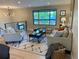 Bright living room featuring a neutral palette, modern light fixtures, and a large window for ample natural light at 794 W Elati Cir, Littleton, CO 80120