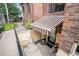 Basement entrance featuring a striped awning over a door with a private patio area at 1423 Dahlia St, Denver, CO 80220
