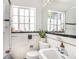 Bright bathroom featuring a window with natural light, a classic tile design, and a mirrored accent at 1423 Dahlia St, Denver, CO 80220