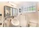 Bright bathroom featuring a modern sink, cabinet, and a unique glass block window for natural light at 1423 Dahlia St, Denver, CO 80220