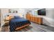 Well-lit bedroom featuring warm wooden furniture, sleek floors, and decorative wall art at 1423 Dahlia St, Denver, CO 80220