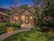 Charming brick home featuring a landscaped front yard and inviting entrance at dusk at 1423 Dahlia St, Denver, CO 80220